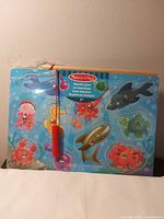 Front view of entire magnetic puzzle showing sea creature pieces and fishing rod