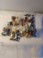 Six bags of assorted beads and jewelry pieces displayed