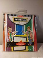 Front view of sealed Melissa & Doug Artist Smock package