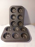 Two metal 6-cavity fluted cake pans front and back