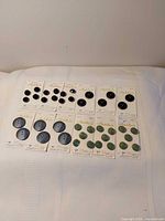 Overview of all 12 Modella button cards on surface