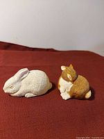 pair of Sandicast bunny figurines on fabric background