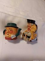 Front view of teapot and creamer showing character forms and painted details