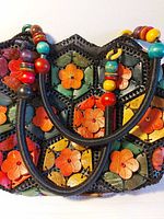 Front of handbag showing multicolor wooden flower tiles and handles