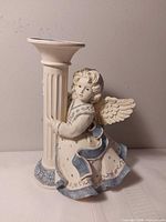 Full view of angel figurine hugging fluted pillar