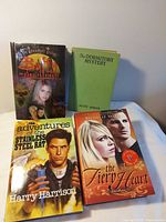 Four books laid out showing front covers