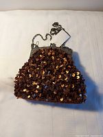 Front view of copper sequin evening purse with metal frame and chain strap