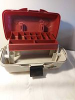 Closed tackle box open showing red tray and compartments