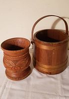 Front view of carved urn beside wooden firkin bucket
