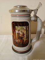 Front view of stein showing embossed blacksmith scene and hinged lid