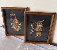 Two framed straw mosaic artworks side by side