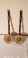 Front view showing pair of brass pans and wood handles