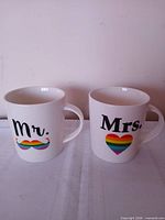 Front view showing Mr. and Mrs. rainbow designs on both mugs