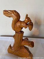 Front view of carved wood squirrel on stump base