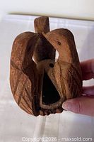 Front view showing carved twin birds and seed opening