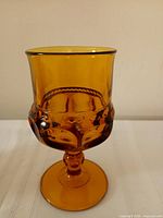 Side view of amber Kings Crown goblet showing thumbprint pattern and stem