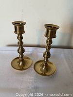 Pair of brass candlesticks standing upright