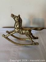Right-side view of brass rocking horse showing form and patina