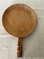 Front view of round hardwood paddle with carved handle