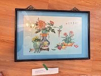 Full view of framed artwork on floor showing frame and subject