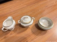 Creamer, sugar bowl with lid, and open view of sugar bowl interior showing iridescence