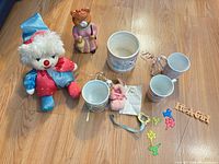 Group shot showing all items on floor: plush clown, cat figurine, ceramic mugs, coin bank, Boo Boo Bunny
