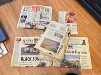Overview of loose and bundled newspaper issues on floor