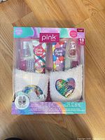 Front of sealed Pink Dazzel spa gift set box showing slippers, lotions, polishes, separators, nail gems