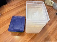Stack of clear plastic bins next to stack of lids