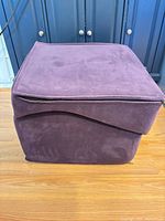 Cube form of purple microfiber ottoman with zipper visible