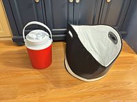 Red insulated jug and black collapsible insulated tote side by side