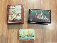 All three tins arranged on floor, showing top designs