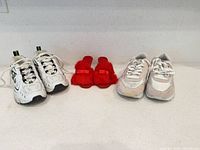 Group shot of three pairs: Nike sneakers, red fuzzy slippers, Reebok sneakers