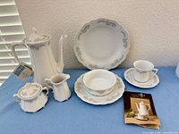 Group shot showing coffee pot with tag, sugar bowl, creamer, plates, bowl, cup and saucer