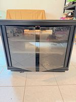 Front view of black cabinet showing smoked glass double doors