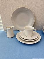 Dinner plate, stacked plates, cup and creamer showing overall style and quantity type