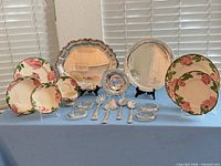 Full lot showing dinnerware, silverplate trays, coasters, and utensils