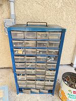 Blue 30-drawer organizer cabinet filled with assorted fasteners
