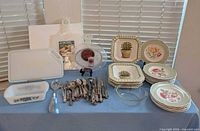 Full lot overview showing plates, bowls, flatware, cutting boards, bakeware