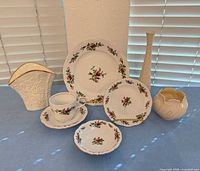 All eight items arranged: five rose pattern china pieces and three ivory porcelain accent pieces