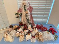Group layout showing standing Santa, 17 Santa head ornaments, poinsettia picks, bells, wreath hanger