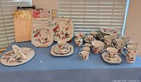 Full lot showing dinnerware pieces and packaged tablecloths