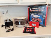 Both appliances with oven box, booklet, red sleeve displayed on countertop