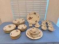 Full set on table showing stacks of plates, cups, serving pieces