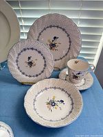 Place setting showing dinner plate, salad plate, soup bowl, cup and saucer
