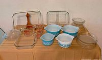 Overall lot with casseroles, measuring cups, clear glass bakeware and wooden utensil displayed