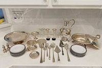 Full layout of all silverplate pieces, utensils, and stack of Royal Doulton plates