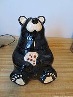Front view of complete black ceramic bear cookie jar