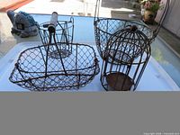 Overview of three wire baskets and birdcage on table
