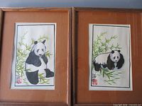 Both framed panda paintings side by side